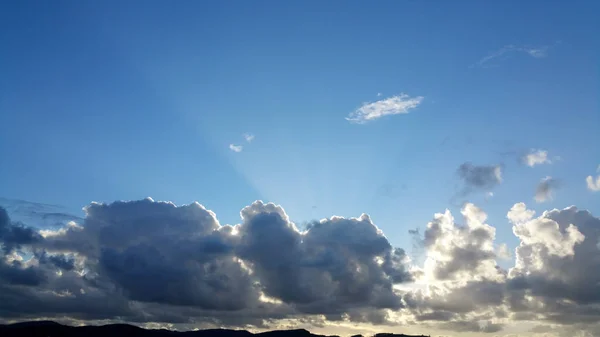 Sonnenstrahlen Über Dunklen Wolken Auf Blauem Himmel — Stockfoto