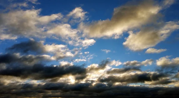Bílé a černé mraky proti modré obloze při západu slunce — Stock fotografie