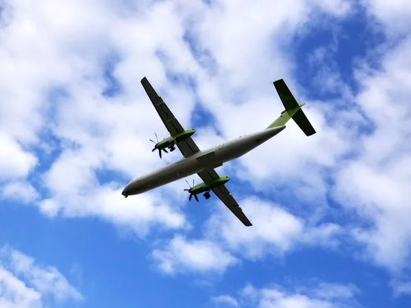 Vy ovanifrån på flygplan under flygning. Flygplan flyger i blå molnig himmel. — Stockfoto