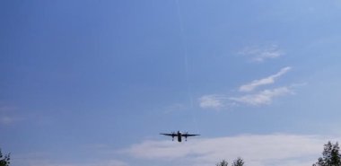 Uçakta yukarıdan bak. Hava aracı mavi bulutlu gökyüzünde uçuyor. Özgün ses.