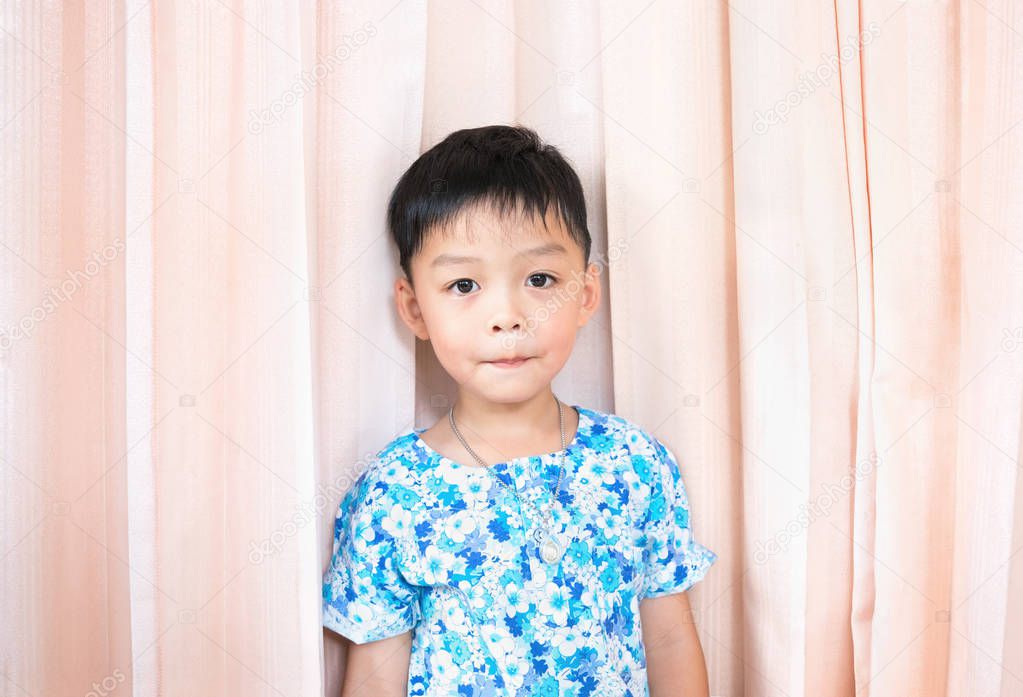 Cute boy wear flower shirt on pink curtain background.Single portrait 