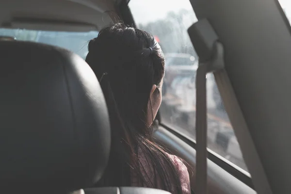 Kız seyahat araba iç içeride pencereden bakıyor ve yol boyunca arkasında