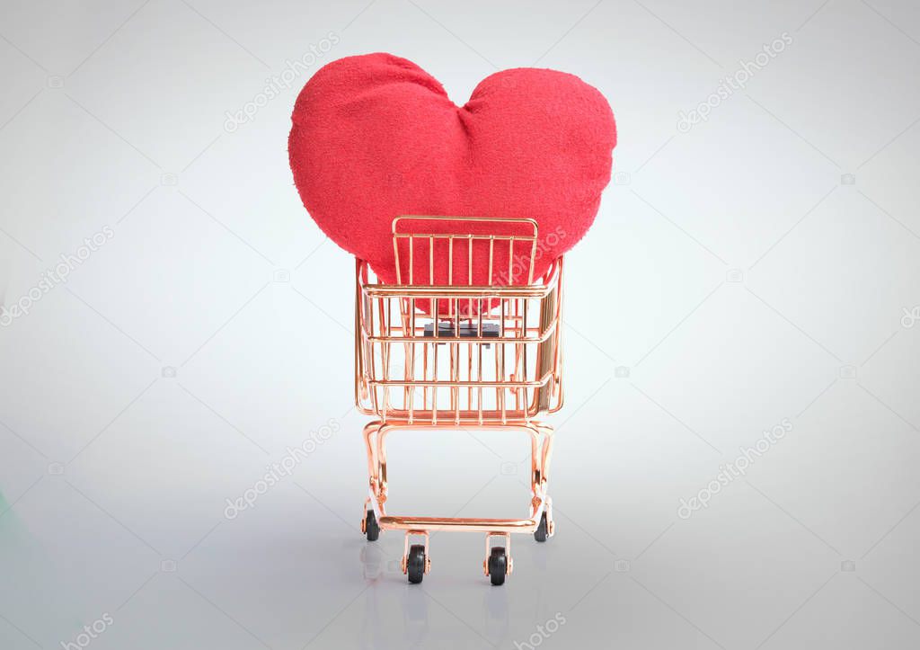 Front view of shopping cart with big red heart isolated and clipping path on grey background
