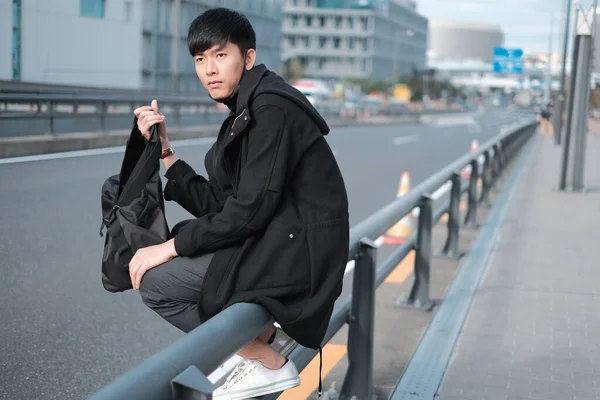 Guapo Joven Asiático Hombre Llevar Bolsa Para Viajar Mientras Sentado —  Fotos de Stock
