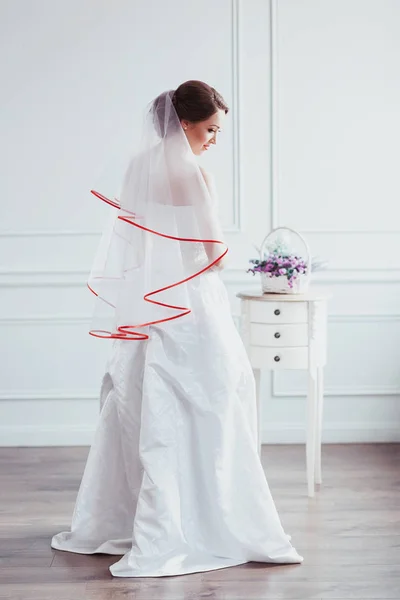 Bela noiva com penteado de casamento de moda - em fundo branco. Retrato de uma jovem. Tiro no estúdio. Menina véu sobre o rosto — Fotografia de Stock