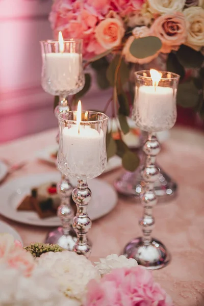 Rosafarbene und weiße Rosen legen Kerzen auf einen Tisch. Selektiver Fokus. Getöntes Image. — Stockfoto