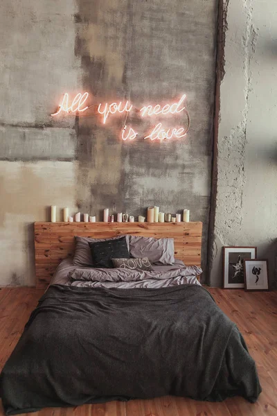 Stylish bedroom in loft style with grey colors and many candles — Stock Photo, Image