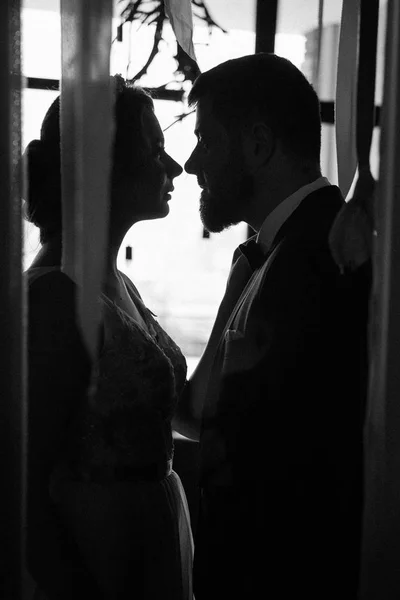 Ritratto di una bella giovane coppia che sta per baciarsi contro la luce dalla finestra — Foto Stock