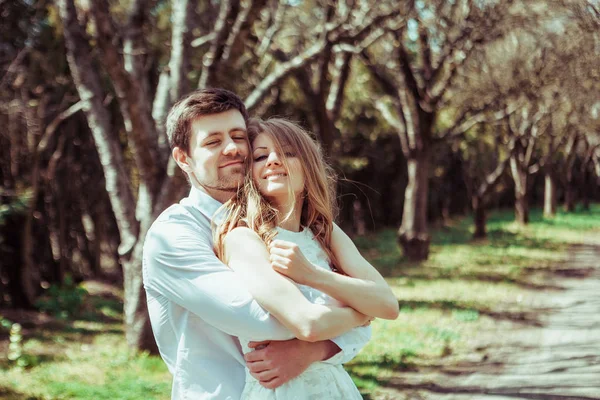 Joven pareja feliz enamorada al aire libre. hombre y mujer cariñosos en un paseo por el parque de primavera —  Fotos de Stock
