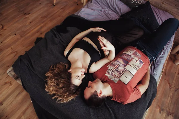 View from the top, young couple embracing in bed, tender. The woman is pregnant — Stock Photo, Image