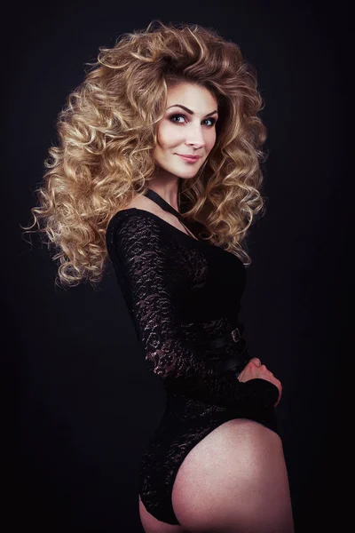 Model with blonde long hair in guipure clothing. Waves Curls Hairstyle. Fashion model with shiny hair. Woman with healthy hair. Girl with luxurious haircut and hair volume