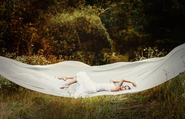 Levitazione ragazza sul panno bianco — Foto Stock