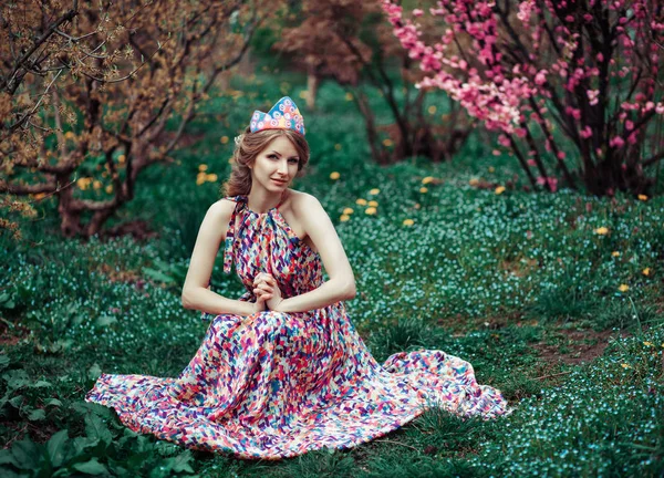 Bella donna con decorazione nei capelli nel parco primaverile con alberi di ciliegio in fiore — Foto Stock