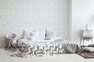 Yatak odası iç yatak ve başucu tablolarla bir tuğla duvar ile