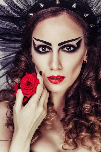 Beautiful woman with dramatic makeup and red lips. Red flower rose. Girl with decoration in her hair. Young lady looking at the camera — Stock Photo, Image