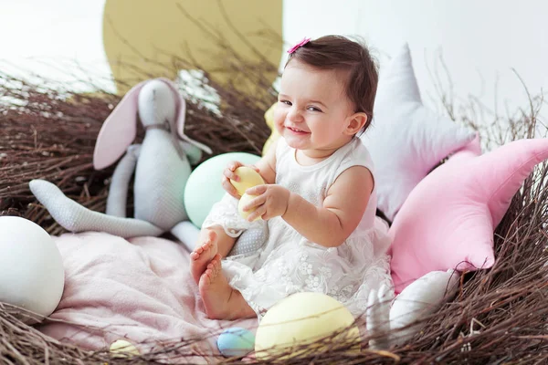 Menina feliz no grande ninho de Páscoa com ovos. Conceito de férias de Páscoa: ninho com lebre bebê — Fotografia de Stock