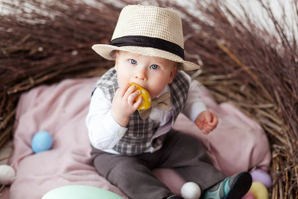 Bebê no ninho de Páscoa com ovos em um terno e chapéu. Conceito de férias de Páscoa: ninho com bebê — Fotografia de Stock