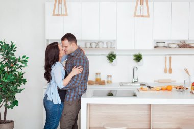 Mutlu çift beyaz loft stile mutfakta sarılma