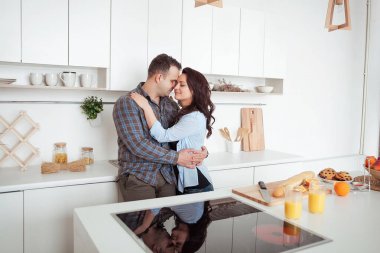 Mutlu çift beyaz loft stile mutfakta sarılma
