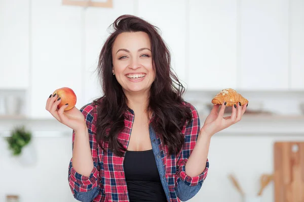 Régime alimentaire. Concept de régime. Nourriture saine. Belle jeune femme au choix entre des fruits et des bonbons. Perte de poids — Photo