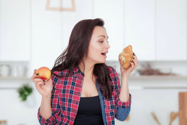 Diéta. Fogyókúra koncepció. egészséges étel. gyönyörű fiatal nő, választás között, gyümölcs és édesség. fogyás — Stock Fotó