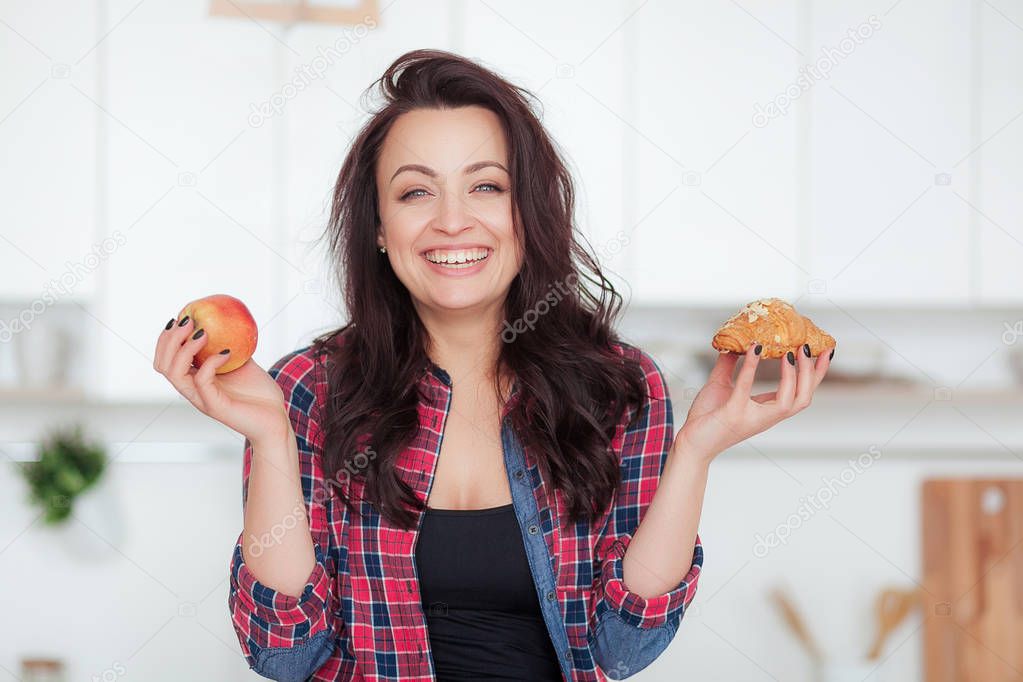 Diet. Dieting concept. Healthy Food. Beautiful Young Woman choosing between Fruits and Sweets. Weight Loss