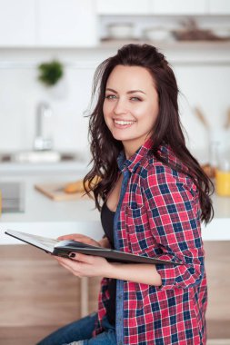 Kahvaltı - gülümseyen kadın okuma kitabı beyaz mutfak, taze portakal suyu