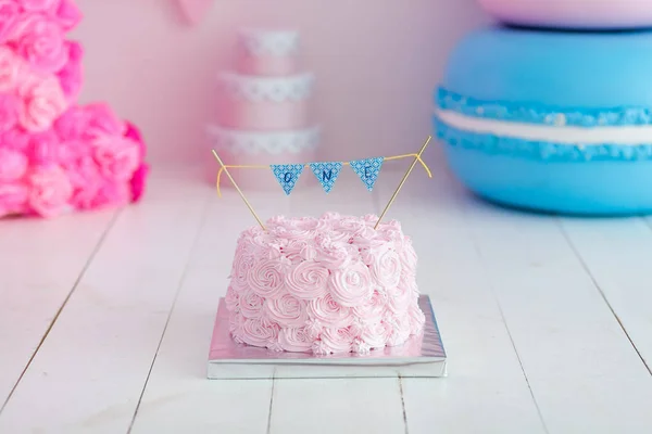 Geburtstag die Torte zertrümmern. Auf weißem Holzgrund steht eine rosa Torte. Erster Geburtstag. — Stockfoto