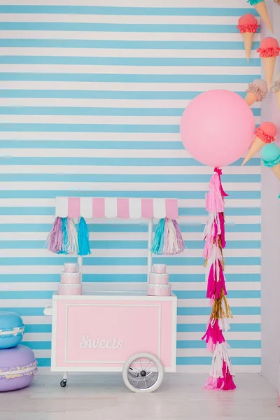 Zona infantil con dulces: piruletas, helados, macarrones, globo y barra de caramelo. Habitación para niños con fondo de rayas azules —  Fotos de Stock