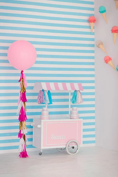 Zona infantil con dulces: piruletas, helados, macarrones, globo y barra de caramelo. Habitación para niños con fondo de rayas azules —  Fotos de Stock