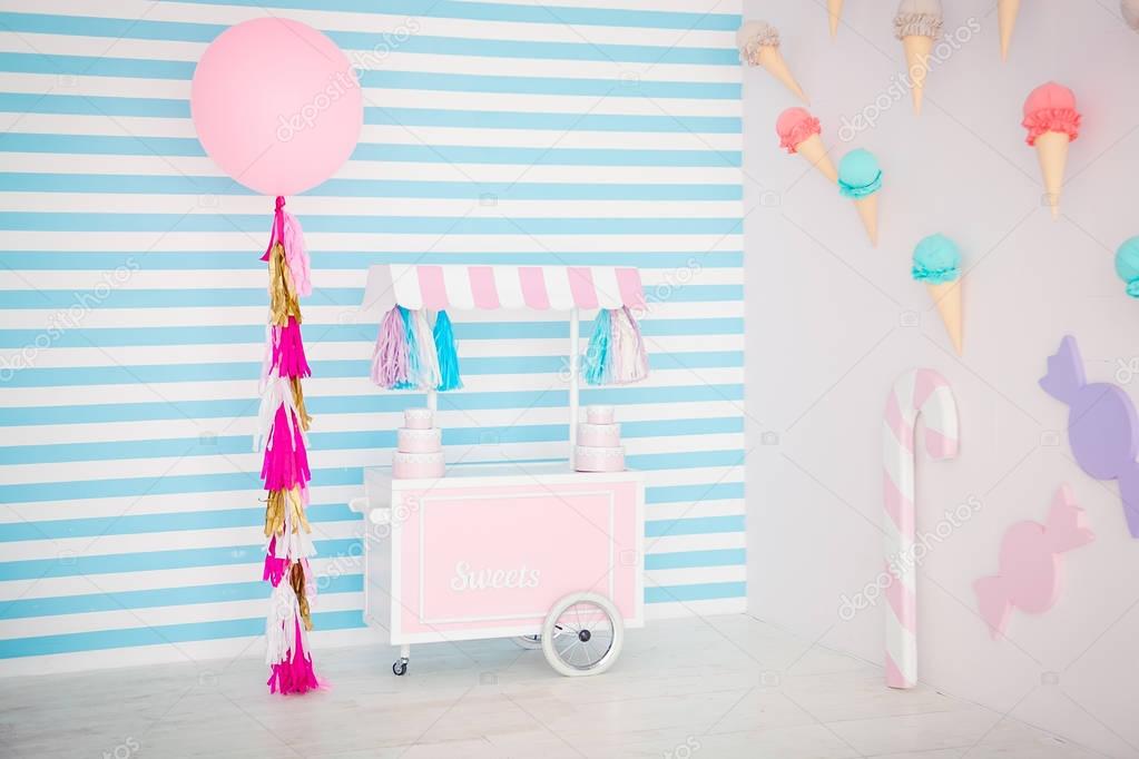 Childrens zone with sweets: lollipops, ice cream, macarons, balloon and candy bar. Children room with blue stripe background