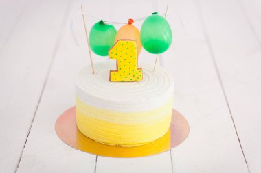 ilk doğum günü pasta şut. Bir numara ve küçük balonlar ile pasta. doğum günü tebrik. Sarı puantiyeli kurabiye ve krema