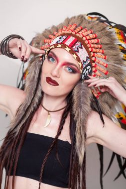 Hint ve kadın ile geleneksel makyaj headdress kameraya bakıyor. Beyaz arka plan üzerinde Kızılderili Kızılderili kadınla bir roach başında