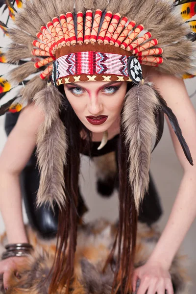 Mujer india con maquillaje tradicional y tocado mirando a la cámara. Mujer india de piel roja sobre fondo blanco con una cucaracha en la cabeza — Foto de Stock