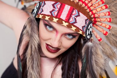 Hint ve kadın ile geleneksel makyaj headdress kameraya bakıyor. Beyaz arka plan üzerinde Kızılderili Kızılderili kadınla bir roach başında