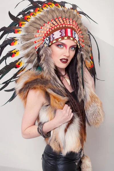 Mujer india con maquillaje tradicional y tocado mirando a la cámara. Mujer india de piel roja sobre fondo blanco con una cucaracha en la cabeza — Foto de Stock