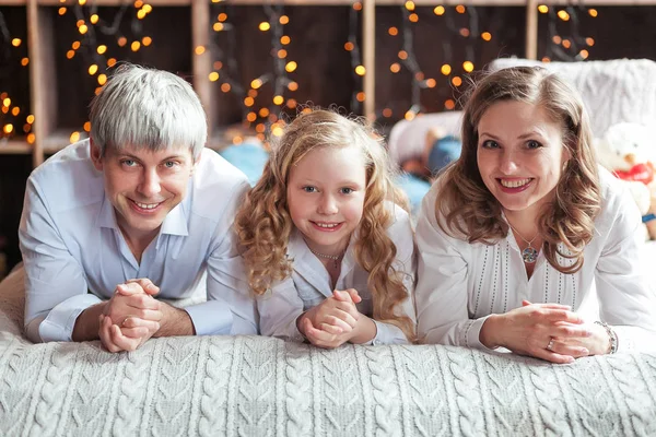 Famiglia seduta a letto sorridente. Buongiorno, luce del giorno . — Foto Stock