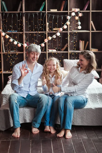 Famiglia seduta a letto sorridente. Buongiorno, luce del giorno . — Foto Stock