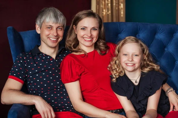 Famiglia in posa in camera con divano sorridente . — Foto Stock