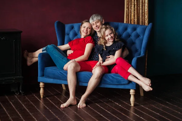 Famiglia in posa in camera con divano sorridente . — Foto Stock