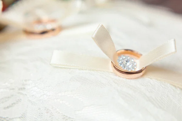 Hermoso fondo con anillos de boda dorados en textil — Foto de Stock