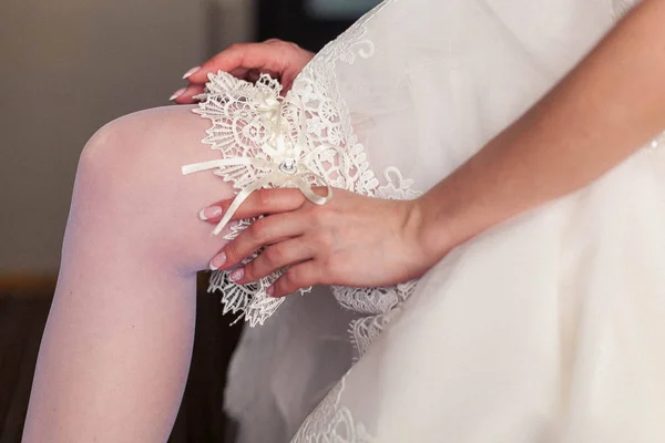 Inizio del giorno del matrimonio. la sposa indossa una giarrettiera nuziale — Foto Stock