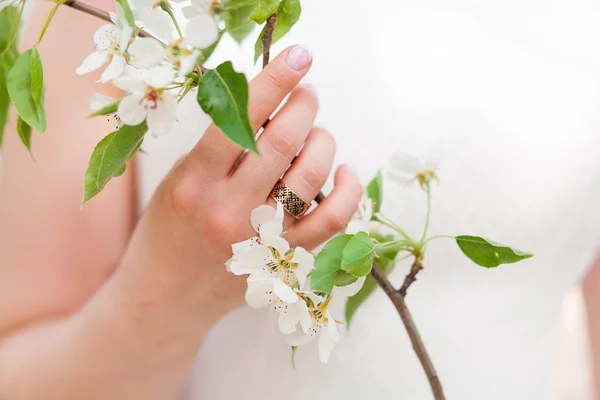 Krásná dívka nevěsta v bílé krajkové šaty, držící větev s třešňový květ — Stock fotografie
