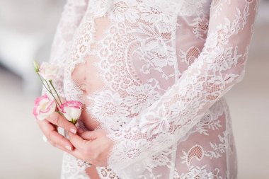 Düğünçiçeği çiçek göbek yukarıda tutan hamile kadın