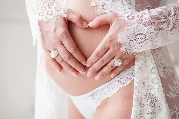 Kobieta, przytulanie piękny brzuch w ciąży. Ręce w kształcie serca — Zdjęcie stockowe