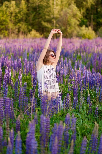 Bella ragazza in un campo di fiori cosmo al tramonto. concetto di libertà.Colore vintage — Foto Stock