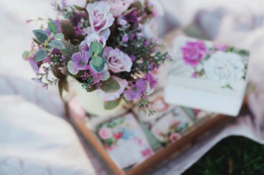 Çimenlerin üzerinde arka plan ile beyaz masa örtüsü üzerinde güzel bir yapay çiçek