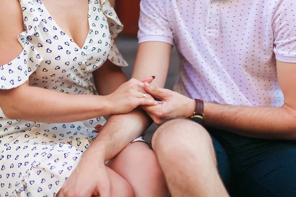 Cropped shot of young couple holding hands while sitting together at home — Stock Photo, Image