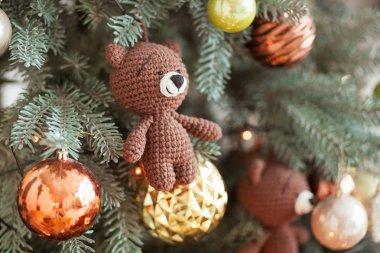 Christmas tree decorations. Toy knitted bear and vintage balls on cristmas tree. Close up shot clipart