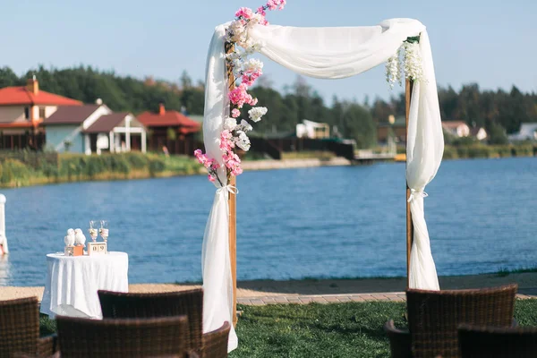 Arco per la cerimonia nuziale, decorati fiori di stoffa verde. Lago sullo sfondo — Foto Stock